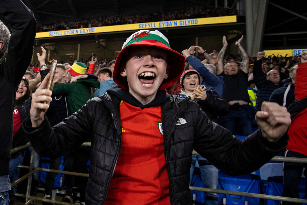Wales fans celebrate their first goal scored by Gareth Bale during the 2022 FIFA World Cup play-off semi-final between Cymru & Austria at the Cardiff City Stadium on the 24th of March 2022